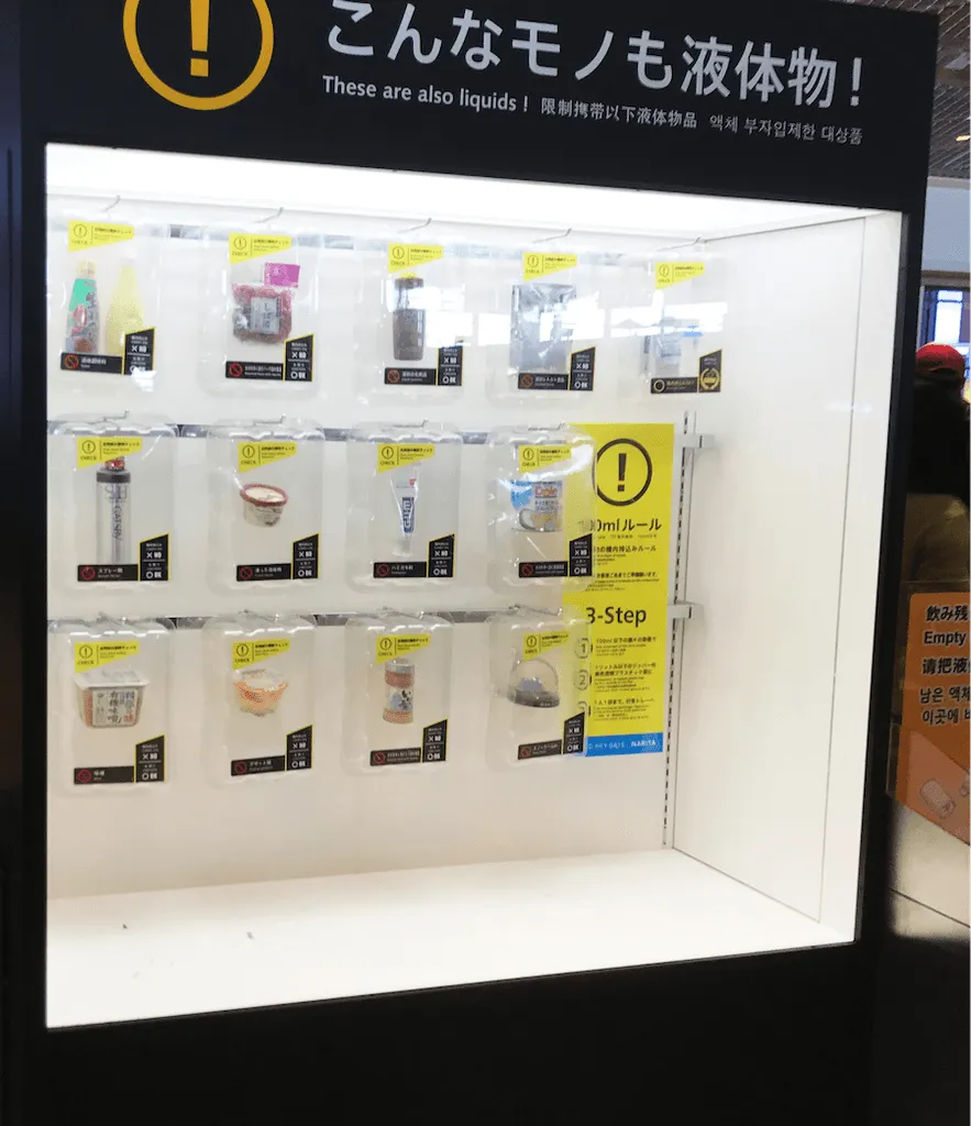 Vitrine d’aéroport présentant les contenants de liquides autorisés en cabine
